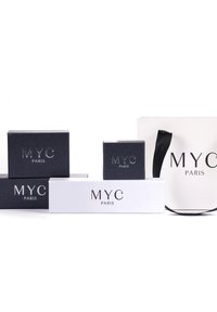 Collezione di quattro scatole e una borsa caratterizzate da un design minimalista. Le scatole sono in bianco e nero con il logo in rilievo "MYC PARIS" in colori a contrasto.