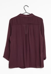 Bordeaux langærmet bluse med krave, som har en plissering ved ryggen. Blødt stof med en glat tekstur og rund nederkant.