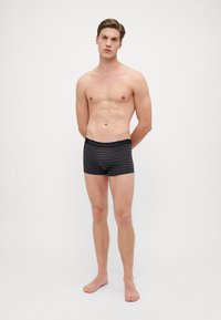 Black boxer briefs with a geometric pattern, elastic waistband labeled "Emporio Armani," fitted design, and smooth fabric texture.