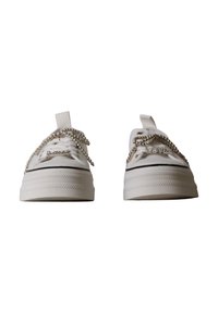 Paire de baskets blanches à plateforme avec lacets en chaîne argentée et charms décoratifs épelant "Love" à l'avant de chaque chaussure.