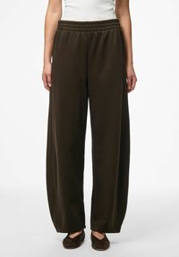 Pantalons larges marron foncé avec une taille élastique, présentant une texture douce et un design simple, sans ornement.