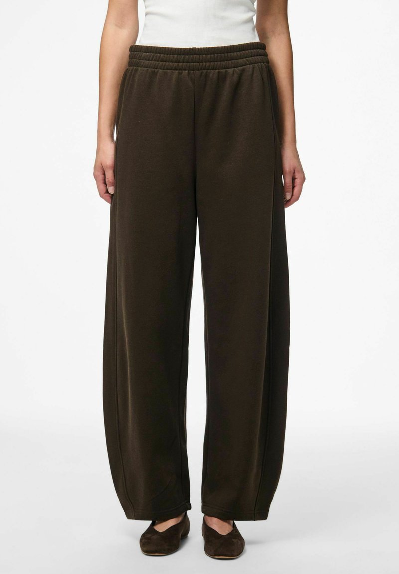 Pantalons larges marron foncé avec une taille élastique, présentant une texture douce et un design simple, sans ornement.