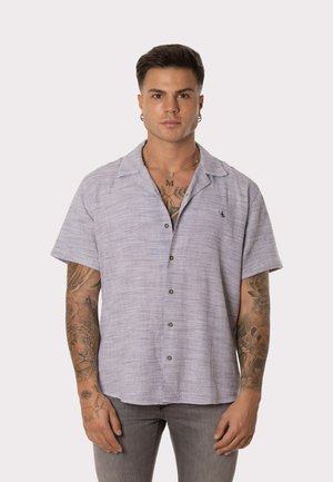 Camisa de manga corta y con botones en tela de color azul claro y blanco, con un patrón texturizado y un pequeño logo en el pecho.