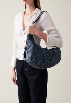 Borsa hobo in blu scuro con un motivo texture, dotata di dettagli in metallo argentato e di un manico etichettato "BONE" per il trasporto.