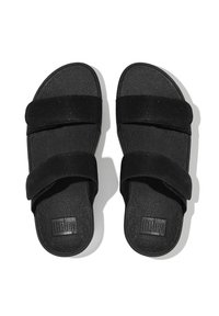 Sandalias negras con dos correas de tela anchas, plantilla texturizada y suela plana. Logo de "FitFlop" grabado en la plantilla. Diseño sencillo.