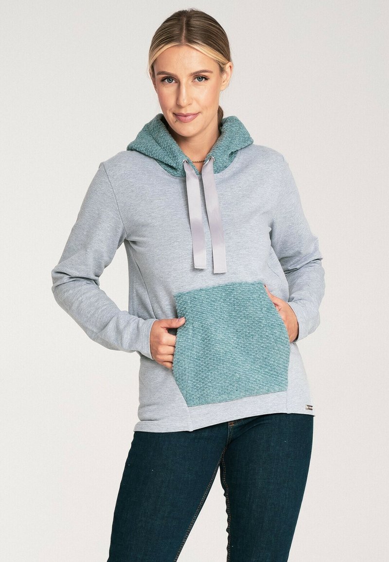 Jasnoszara bluza z kapturem z turkusową teksturowaną kieszenią i dopasowanym kapturem, z szarymi sznurkami i luźnym krojem. Miękka faktura tkaniny.