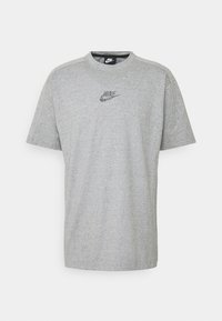 Pelēks īsām piedurknēm T-krekls, izgatavots no mīksta auduma, ar diskrētu daudzkrāsu Nike logotipu uz krūtīm un klasisku apaļu kakla izgriezumu.