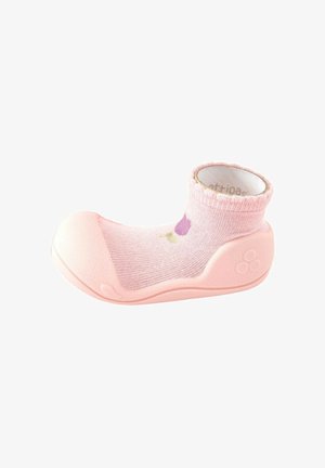 Zapato calcetín para bebé en rosa con suela flexible y puntera reforzada, con un pequeño diseño de flor morada en la parte superior del calcetín.