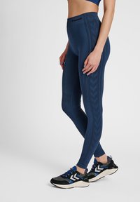 Námořnické legíny s vysokým pasem, zdobené texturovanými vzory po stranách. Nosit s černými a modrými sportovními botami.