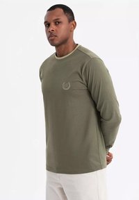 Olivegrünes Langarmshirt aus einer Baumwollmischung mit Rundhalsausschnitt, dezentem Logo auf der Brust und lockerer Passform.