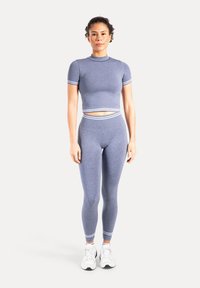 To-delt træningssæt i lyseblåt stof. Toppen har korte ærmer og et cropped design med hvide striber. Leggings sidder tæt og har matchende striber.