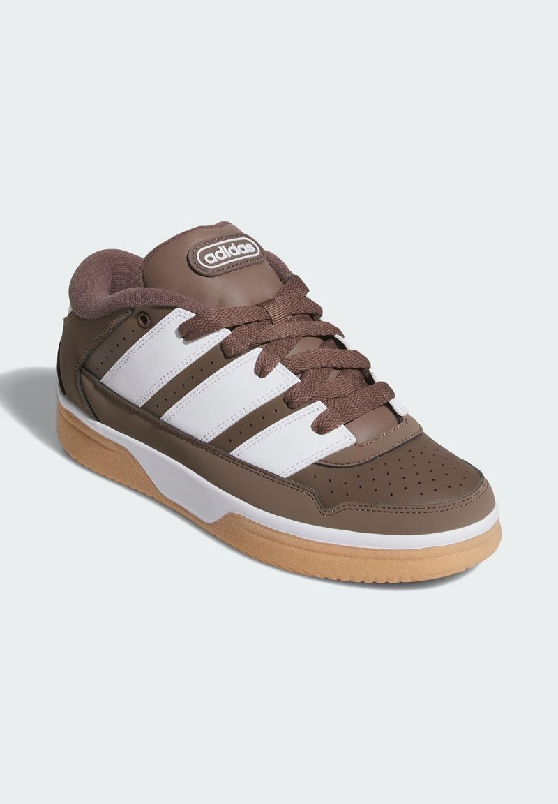 Brown leather sneaker with white accents, featuring three stripes on the side, rounded toe, and rubber gum sole. Perforated design at the toe.
