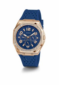 Orologio in silicone blu con cassa ottagonale in oro rosa, accenti di cristallo attorno al quadrante e grandi numeri su un quadrante blu.