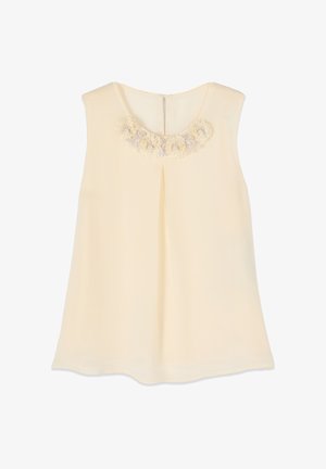 Blusa senza maniche color crema con scollo rotondo, piega frontale e fiori di tessuto decorativi lungo il colletto.