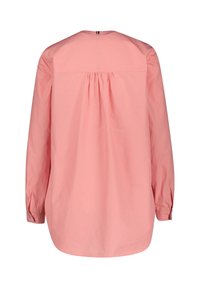 Chemise à manches longues en coton rose pâle avec un pli dans le dos, un ourlet arrondi et des poignets boutonnés. Col simple au design épuré.