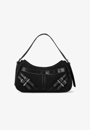 Bolso de mano negro con un material suave similar al ante, con acentos de cuero brillante y hebillas decorativas en las correas. Forma curva, con una sola correa.