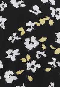 Tissu noir avec des formes florales blanches dispersées et de petits accents en forme de feuilles jaune pâle dans un motif abstrait.