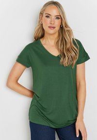 Kortärmad T-shirt med V-hals i mörkgrön, tillverkad av mjukt material. Har en avslappnad passform och en jämn textur utan mönster eller detaljer.