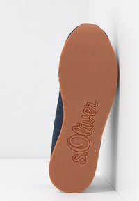 Sole obuvi S. Oliver s texturovanou oranžovou gumovou podrážkou, s logem a tmavě modrým textilním svrškem se šitými vzory.