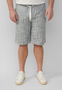 Shorts rayés en bleu et blanc, en mélange de coton, avec une taille à cordon de serrage et une coupe décontractée. Associés à des baskets blanches.
