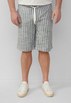 Gestreifte Shorts in Blau und Weiß, aus Baumwollmischung, mit einem Kordelzugbund und lockerer Passform. Kombiniert mit weißen Sneakers.