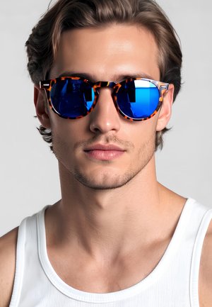 Occhiali da sole rotondi con lenti a specchio blu e motivo tartarugato. Montatura in plastica leggera, con finiture argentate sulle tempie.