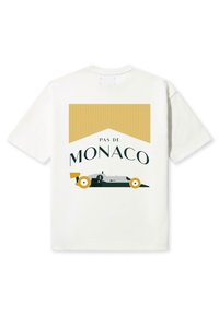 Hvid bomulds t-shirt med et grafisk motiv af en racerbilm med gule hjul og accenter, mod en stribet baggrund i gult og grønt.