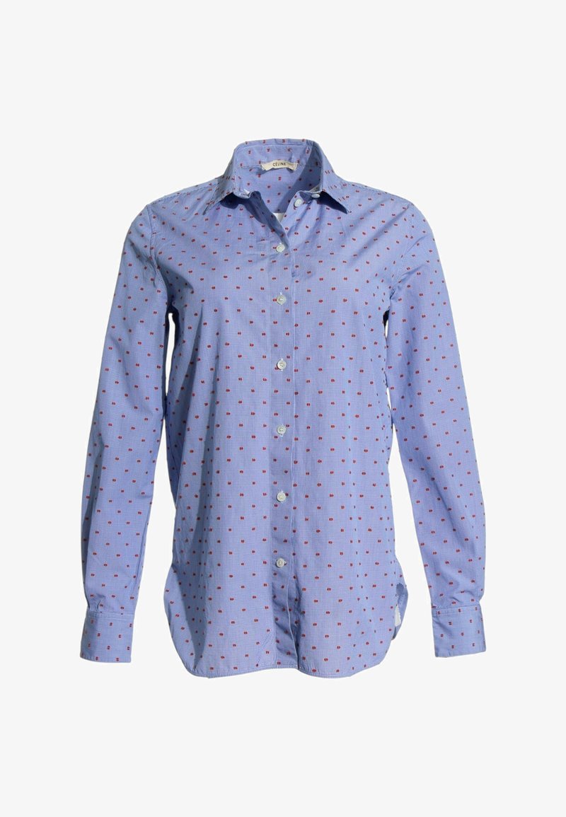 Chemise bleue à manches longues avec un petit motif de points rouges et un col pointu.