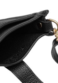 Bolso de mano de cuero negro con un acabado texturizado, que presenta un cierre de hardware en tono dorado y una correa plana. El interior es abierto sin compartimentos visibles.