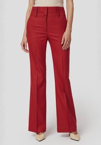 Czerwone rozszerzane spodnie z wysokim stanem, z detalicznym przeszyciem i kieszeniami bocznymi. Wykonane z gładkiego materiału, wykończone elegancką sylwetką.