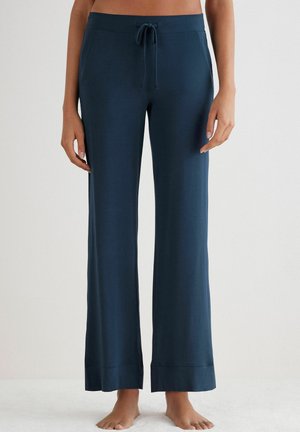 Marineblauwe loungebroek met een trekkoord tailleband, wijde benen en een zachte textuur. Heeft een contrasterende gestikte zoom aan de onderkant.