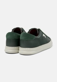Sneaker in pelle verde con retro in suede, design a profilo basso, suole a contrasto bianco sporco e dettaglio cucito visibile lungo il lato.