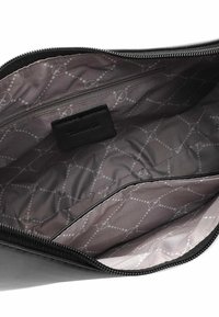 Černá zipová taška uvnitř s hladkým šedým podšívkou s diamantovým vzorem a malou zipovou kapsou. Štítek na boku.