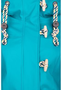 Turkusowa wodoodporna kurtka z drewnianymi zapięciami i plecionymi sznurkami w żółtym, białym i granatowym kolorze. Gładka tekstura, nowoczesny design.