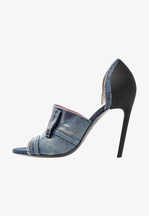 Denim högklackad mule med öppen tå, med en sliten textur, böjda kanter och en stilren svart klack. Accenter inkluderar en framflik.