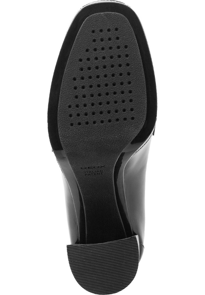 Suela de zapato de charol negro con un acabado suave, que presenta un tacón de goma texturizado y perforaciones para mayor transpirabilidad.