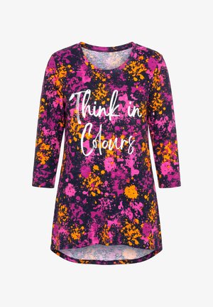 Camisa de manga larga con patrón salpicado en púrpura, naranja y rosa y texto en letra blanca que dice "Think in Colours" en el frente.