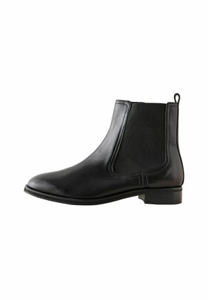 Botines de cuero negro con paneles laterales elásticos, puntera redondeada, detalles de costura mínimos y un tacón corto tipo bloque, diseñados para facilitar el uso.