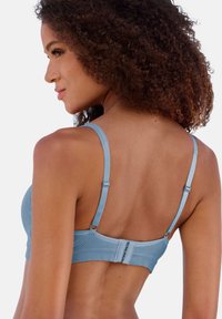 Hellblauer BH aus strukturiertem Stoff, verstellbaren Trägern und einem Haken- und Ösenverschluss auf der Rückseite. Entworfen mit einer glatten, nahtlosen Form.
