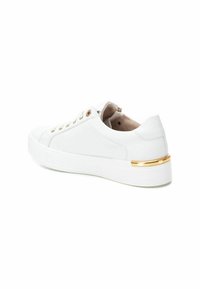 Zapatilla blanca hecha de cuero suave con puntera redonda, ojales en tono dorado y un acento dorado en el talón. La suela de plataforma añade altura.