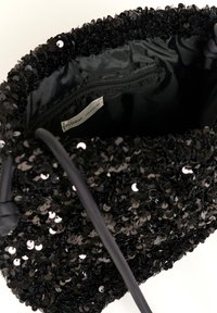 Bolso de mano negro con lentejuelas y superficie texturizada, con un forro interior suave y un bolsillo con cremallera. Incluye una correa ajustable.
