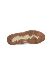 Schoenzool met een bruin rubberen buitenkant met textuurpatronen en groeven voor grip, met een beige tussenzool voor ondersteuning.