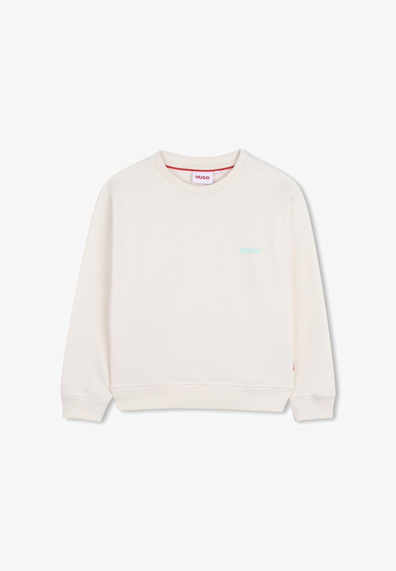 Sweatshirt beige clair à col rond, poignets et ourlet côtelés. Présente un petit logo "HUGO" vert sur la poitrine. Texture douce, design décontracté.