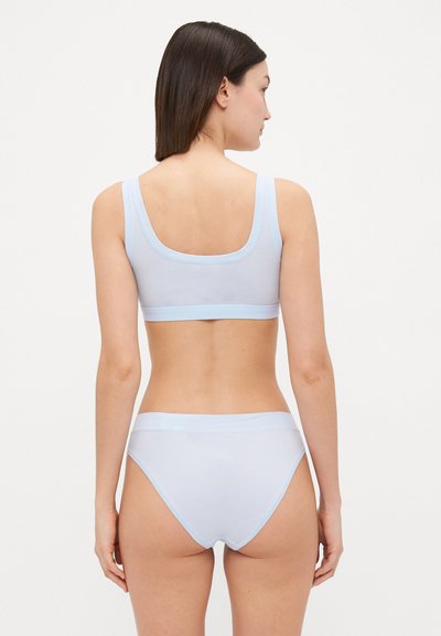 Set de sutien și chiloți de culoare albastru deschis, realizat dintr-un material neted cu margini în contrast. Sutienul are bretele late; chiloții au o tăietură de înălțime medie și un elastic flexibil la talie.