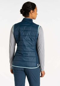 Marineblauer Puffer-Weste mit gestepptem Muster, hellblauen Akzenten, hohem Kragen und Reißverschluss vorne, getragen über einem grauen Langarmshirt.