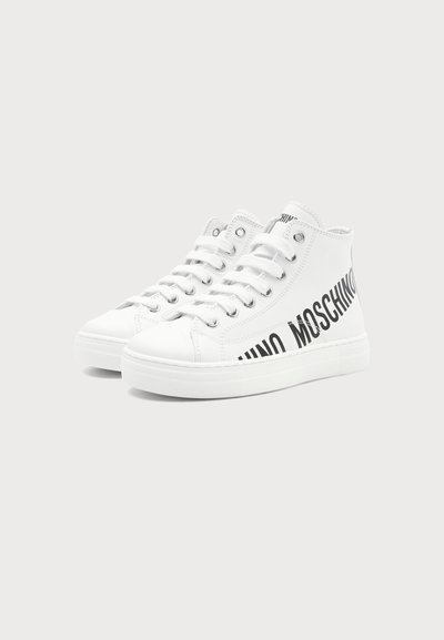 Baskets montantes blanches avec lacets blancs et texte noir audacieux "MOSCHINO" sur le côté, sur un fond clair uni.