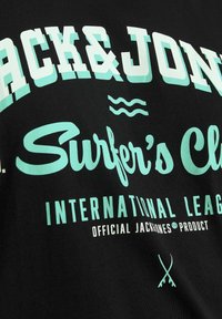 Schwarzes T-Shirt mit mintgrünem grafischem Text, einschließlich "Jack & Jones" und "Surfer's Club", mit Wellenmotiven und Logoakzenten.