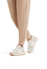 Sneakers sportivi bianchi e beige con accenti rosa, caratterizzati da una tomaia texture, suola ammortizzata e un classico design con lacci.
