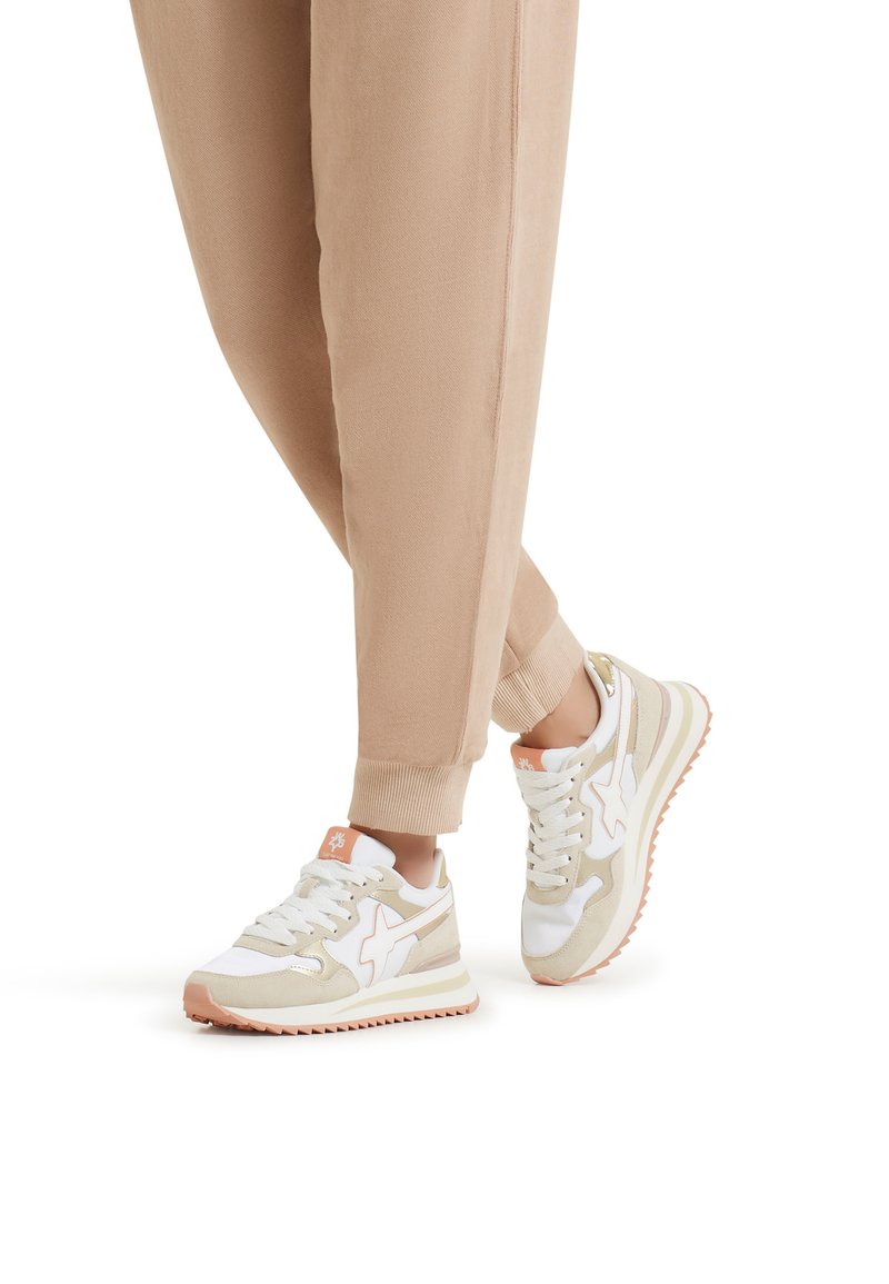 Sneakers sportivi bianchi e beige con accenti rosa, caratterizzati da una tomaia texture, suola ammortizzata e un classico design con lacci.