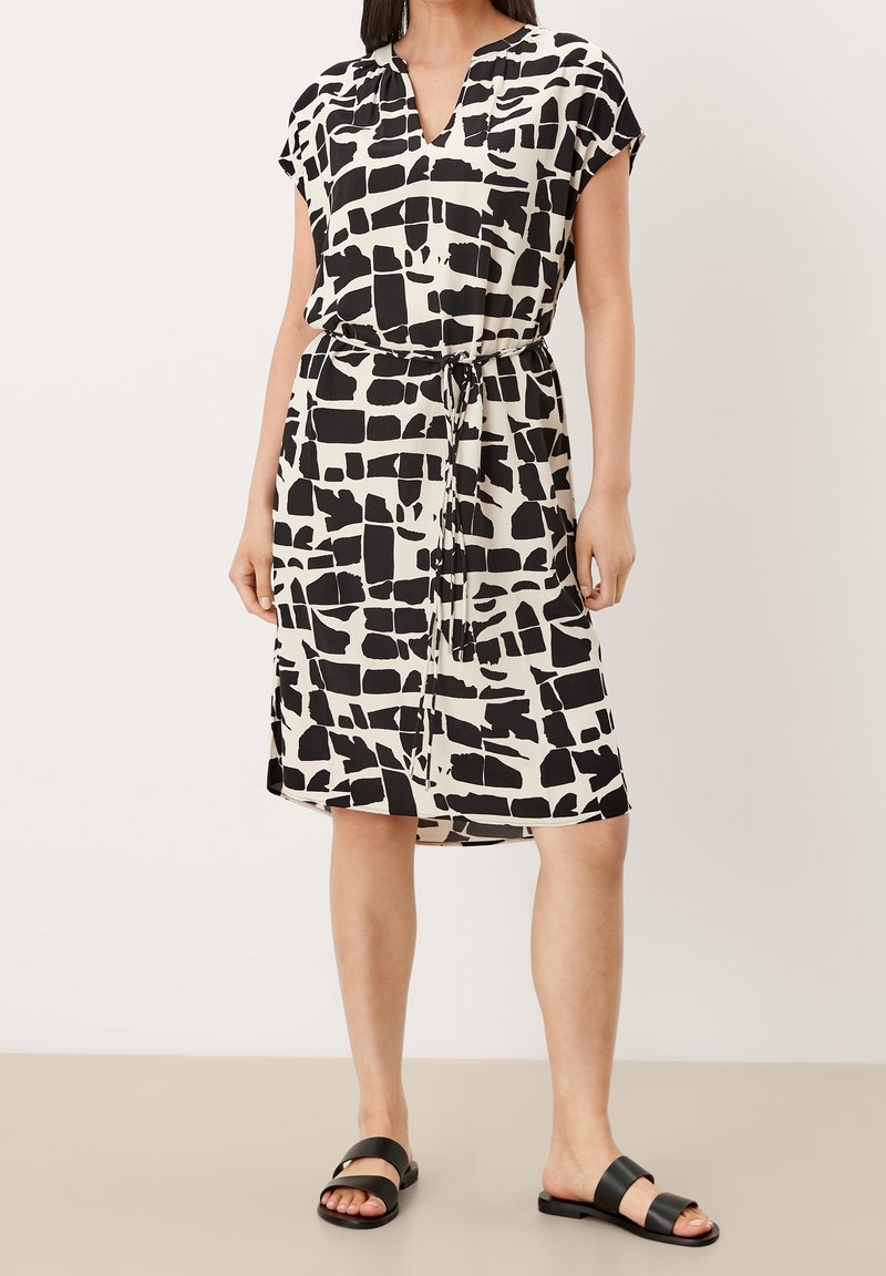 Černobílé šaty se vzorem, výstřihem do V, krátkými rukávy a stahováním v pase, vyrobené z lehké látky, s volným střihem.